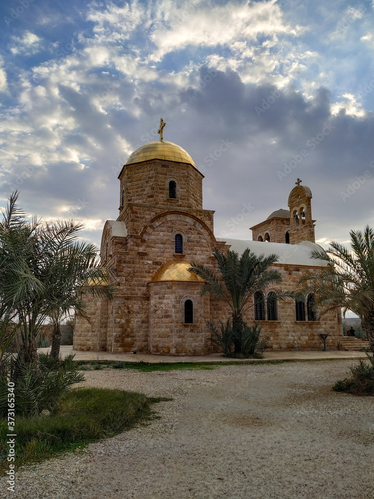 View of St. John the Baptist Greek Orthodox Church, located at the site of the baptism of Jesus Christ on the Jordan River. Blue sky with some clouds.