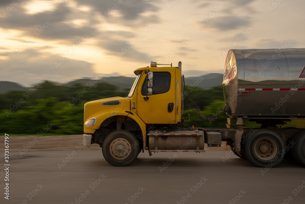Yellow truck with fuel load on a rural highway in Colombia.