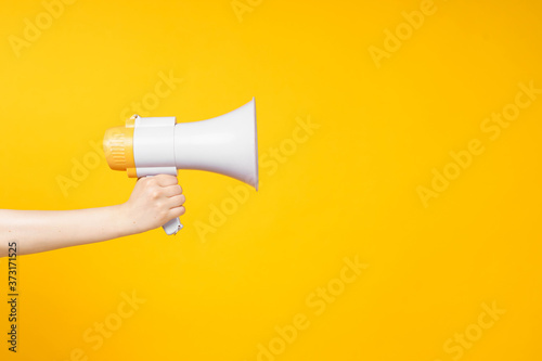 Woman's hand holding a megaphone, copy space.