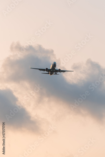 Plane flying low against light.