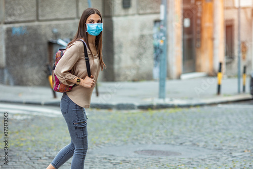 Girl going to school with protective mask. Woman on school campus. Mask for COVID-19. Back to school. Teenage Girl wearing backpack and facial mask to protect herself from Coronavirus