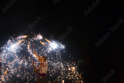 Fire show at an event in the dark. Fire show. The fakir waves fire against the explosion of firecrackers. Nightly entertainment performance great show. Fire show, dancing with flame photo