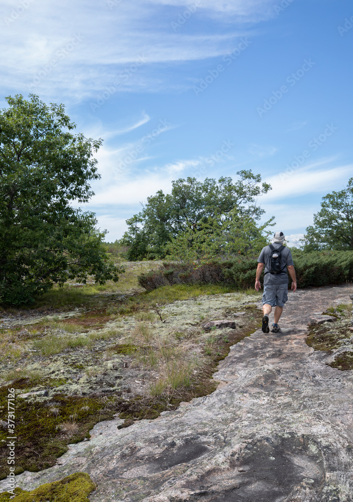 Man hiking a beautiful bedrock trail at Torrance Barrens conservation area 
