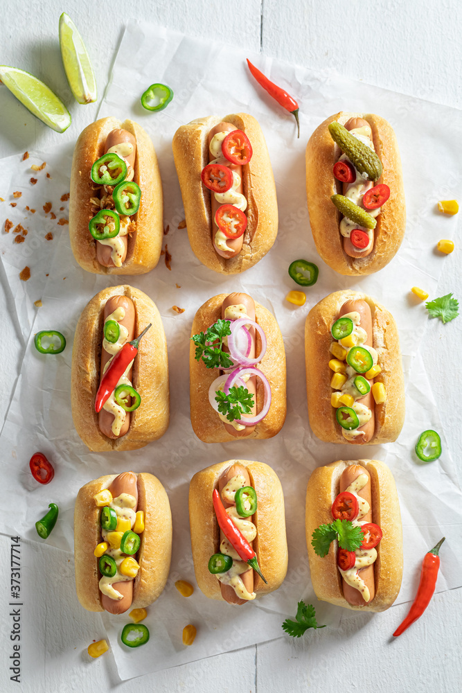 Fototapeta Tasty mini hot dogs with herbs and mustard