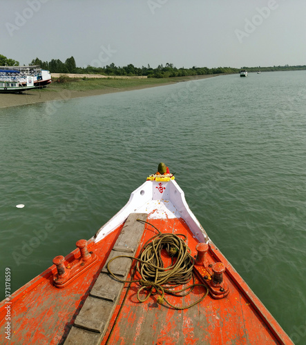 The prow of a bright red Fishing and tourist boat sailing in the Bay of Bengal- Sundarban, India- 9th Feb 2018