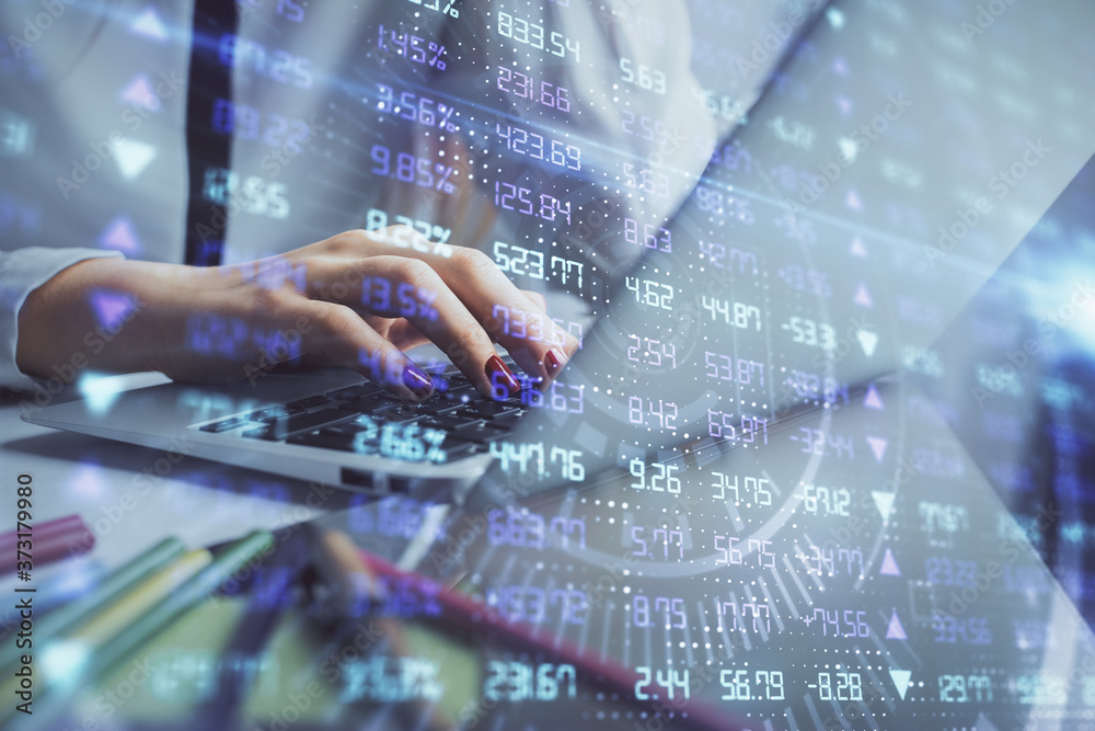 Fototapeta premium Double exposure of woman hands typing on computer and financial graph hologram drawing. Stock market analysis concept.