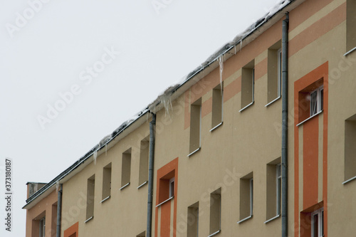 niebezpieczne wielkie sople lodowe zwisające z dachu photo