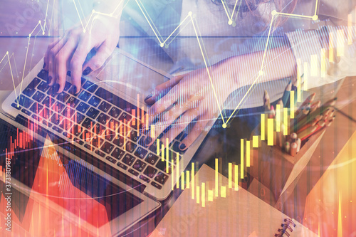 Double exposure of woman hands typing on computer and forex chart hologram drawing. Stock market invest concept.