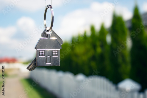Metal keys to a new house on the background of residential buildings. Concept for buying and renting apartments.