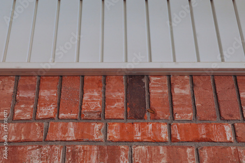 Orange bricks and white vinyl siding