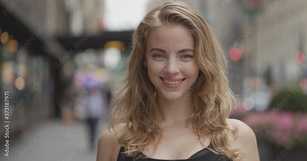 Young blond woman in city face portrait smile happy