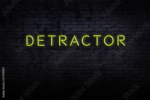 Neon sign. Word detractor against brick wall. Night view photo