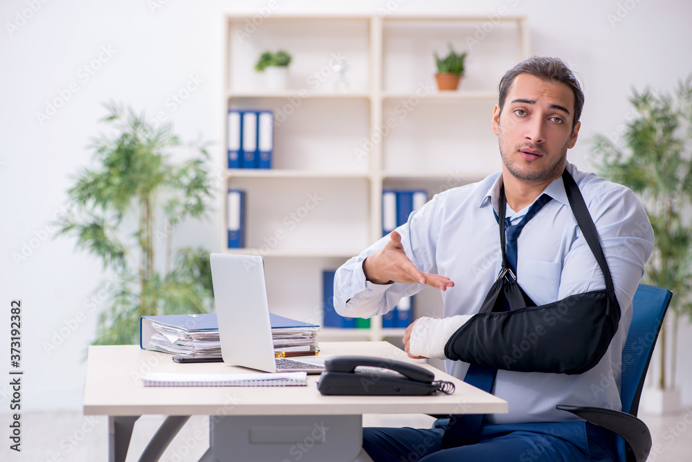 Injured male employee at workplace after accident Injured male employee at workplace after accident