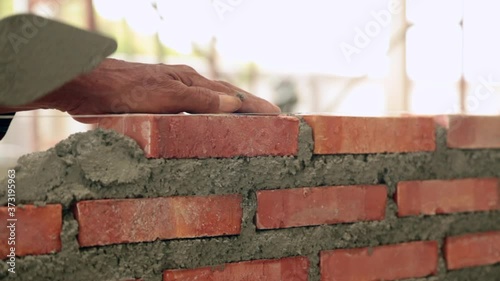 Bricklayer worker installing brick masonry