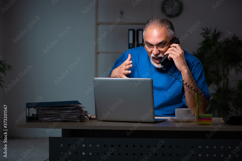 Aged male doctor in the hospital at night Aged male doctor in the hospital at night