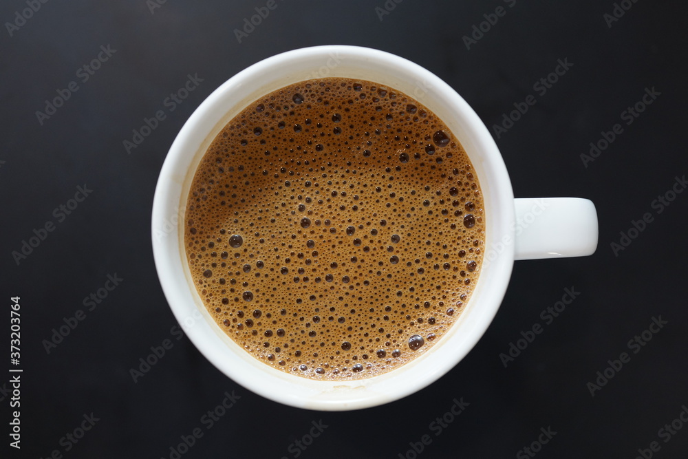 Directly above view a cup of coffee on dark background Directly above view a cup of coffee on dark background