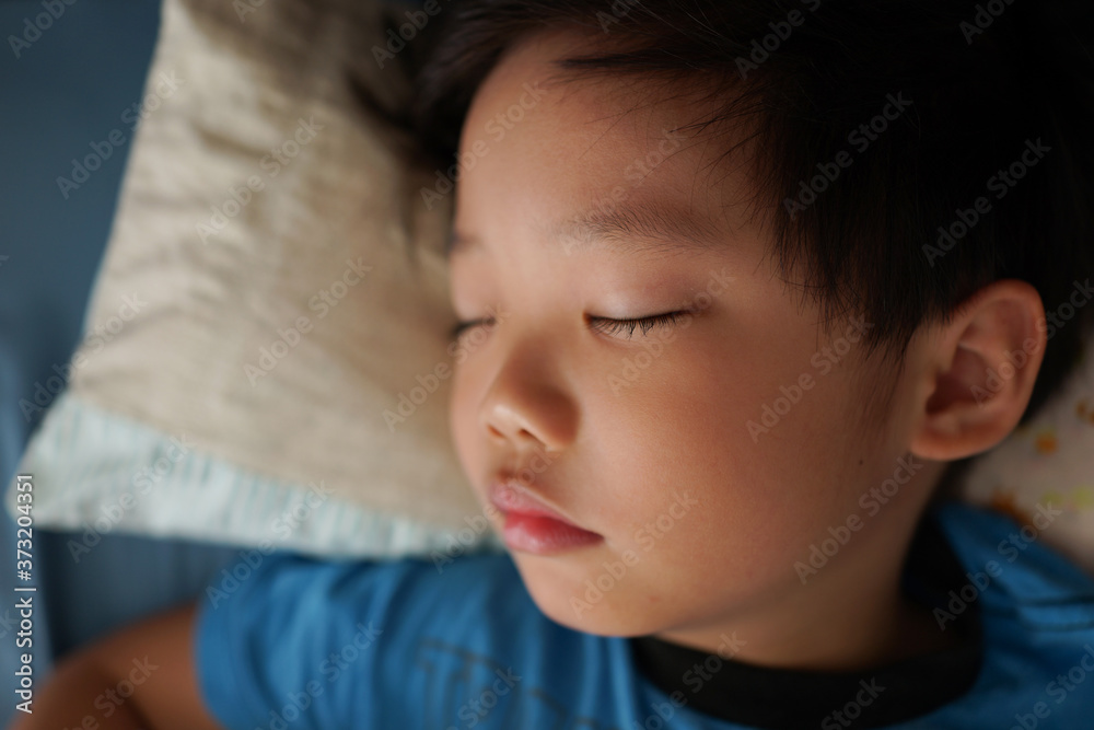Portrait of a tired little Asian boy sleeping on his bed. Portrait of a tired little Asian boy sleeping on his bed.