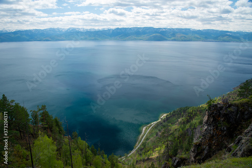 The coast of Lake Baikal on the Circum-Baikal Railway. Circum-Baikal railway tour in Siberia with trees, cliffs and mountains at coast. Baikal. 