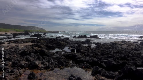 Low angle view of surf breaking on a rocky beach in east Oahu, Hawaii.