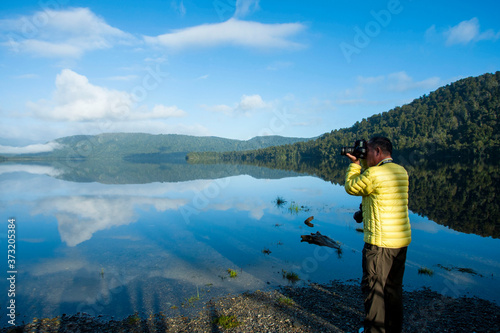 ニュージーランド、南島、マポウリカ湖を撮影するアクティブシニア男性