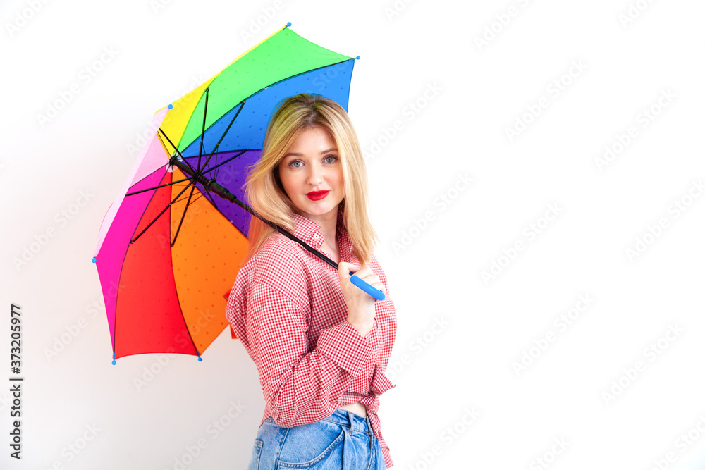 Fototapeta premium Young beautiful woman holding colored umbrella on white background