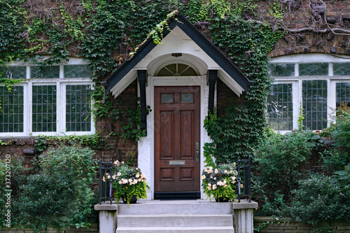 Vászonkép front door of old vine covered house with leaded glass windows