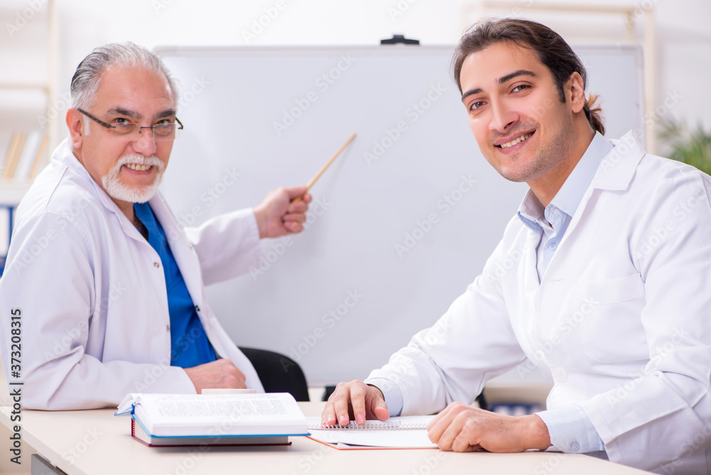 Experienced doctor teaching young male assistant Experienced doctor teaching young male assistant