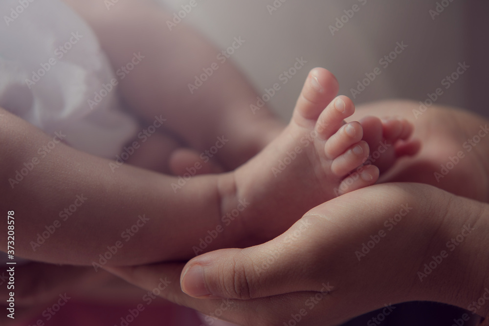 Parent holding in the hands feet of newborn baby. Parent holding in the hands feet of newborn baby.
