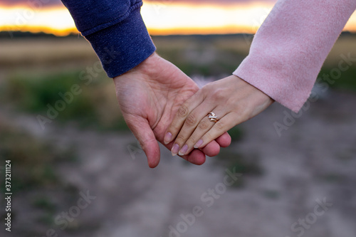A loving young couple holding hands. Hands of a girl and a guy close-up. On a date boy and girl on the nature © Анатолий Савицкий