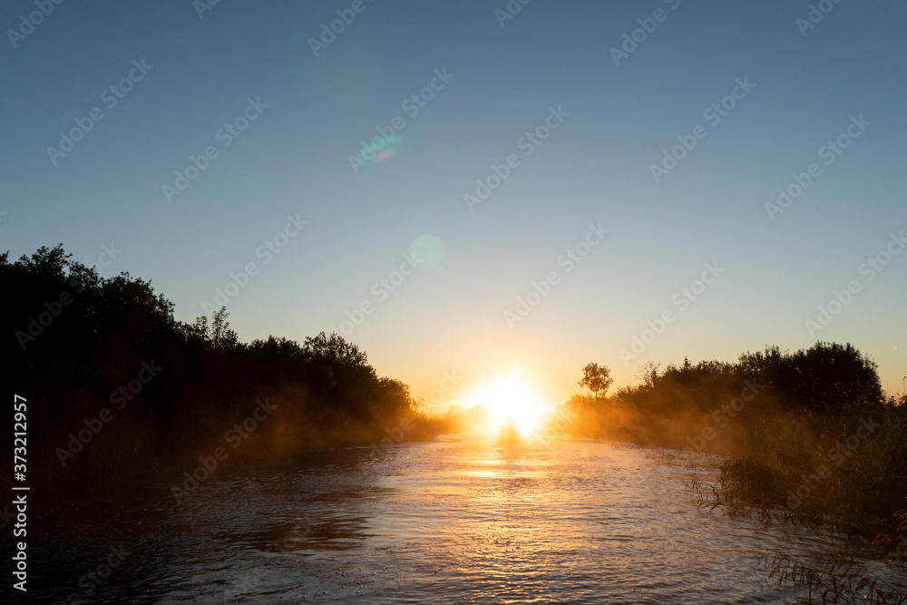 Sunrise sky background. Gold sunrise sky with sky clouds over the lake with fog.Crystal clear water texture. Small waves with water reflection Sunrise sky background. Gold sunrise sky with sky clouds over the lake with fog.Crystal clear water texture. Small waves with water reflection