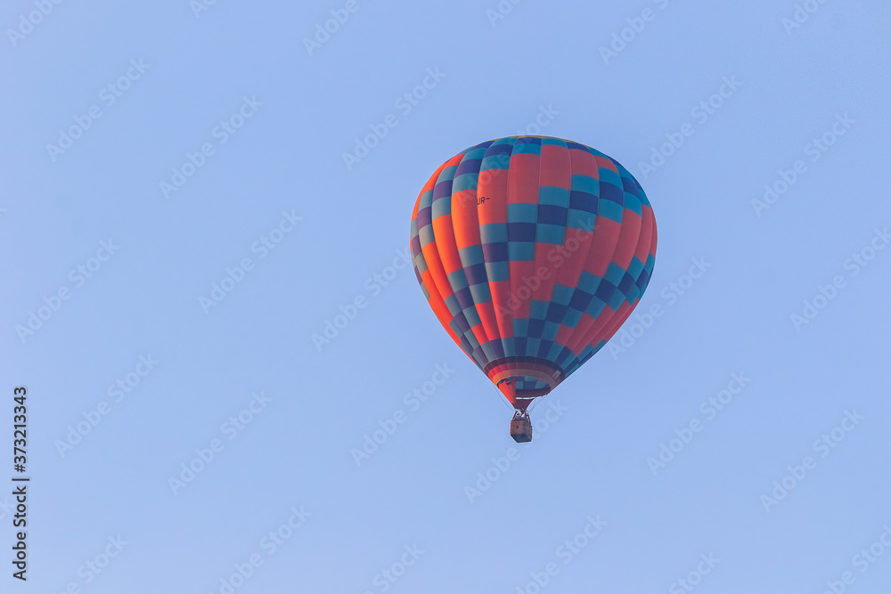 Hot air balloon in flight against a background of blue sky. Colorful balloon watercolor painting. Hot air balloon in flight against a background of blue sky. Colorful balloon watercolor painting.