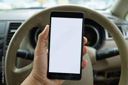 Close up adult hand holding a blank screen smartphone in car © ltyuan
