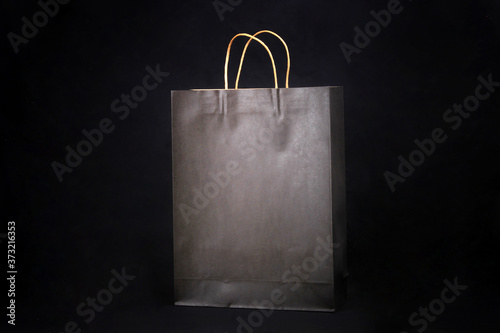 Plain brown paper bag packaging on a black background with copy space