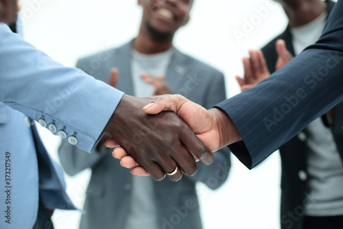 young business partners shaking hands to applause of employees