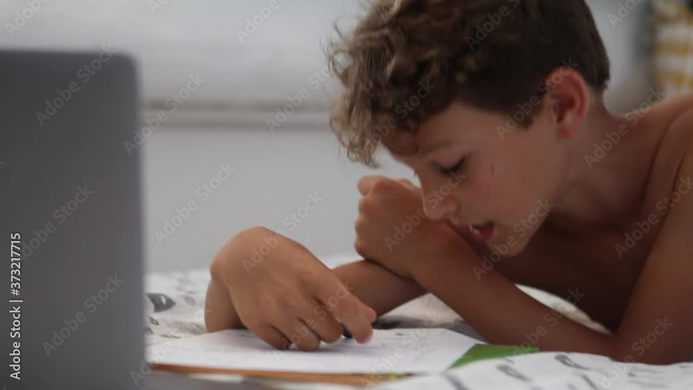 Candid kid doing homework. Authentic child studies online class from home Candid kid doing homework. Authentic child studies online class from home