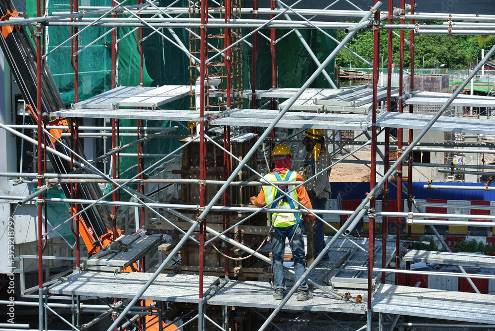 Fototapeta premium KUALA LUMPUR, MALAYSIA -MARCH 05, 2020: Construction workers installing & fabricating timber formwork at the construction site. The formworks made from timber and plywood. 