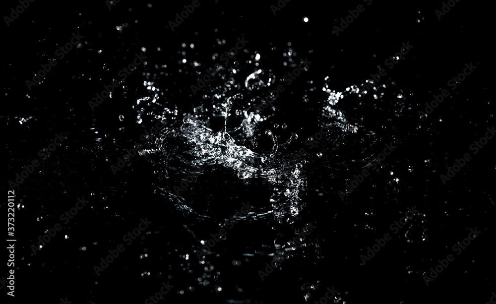 Splashes and drops of water are on a black background.