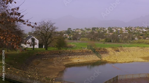 Reveal farm estate behind tree with autumn leaves