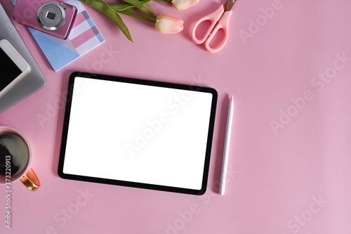 Top view mockup digital tablet on pink office desk.