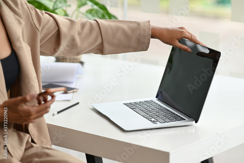 Closeup businesswoman turn opening laptop computer on modern workplace.