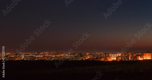 Time-lapse of a city during the night, shot from a hill.