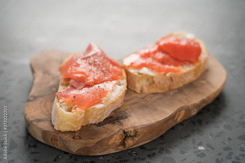 Sandwich with smoked salmon and cream cheese on olive woob board Sandwich with smoked salmon and cream cheese on olive woob board