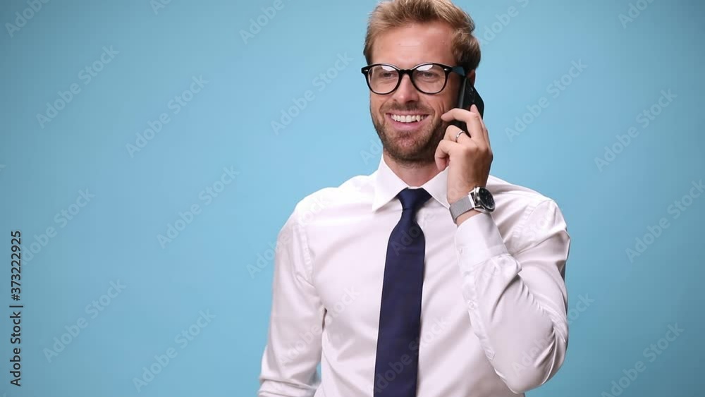 smart casual man talking on his phone, laughing, being happily surprised and celebrating succes on blue background smart casual man talking on his phone, laughing, being happily surprised and celebrating succes on blue background