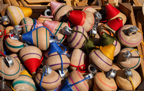 Closeup of wooden humming tops with threads in a box under the sunlight photo