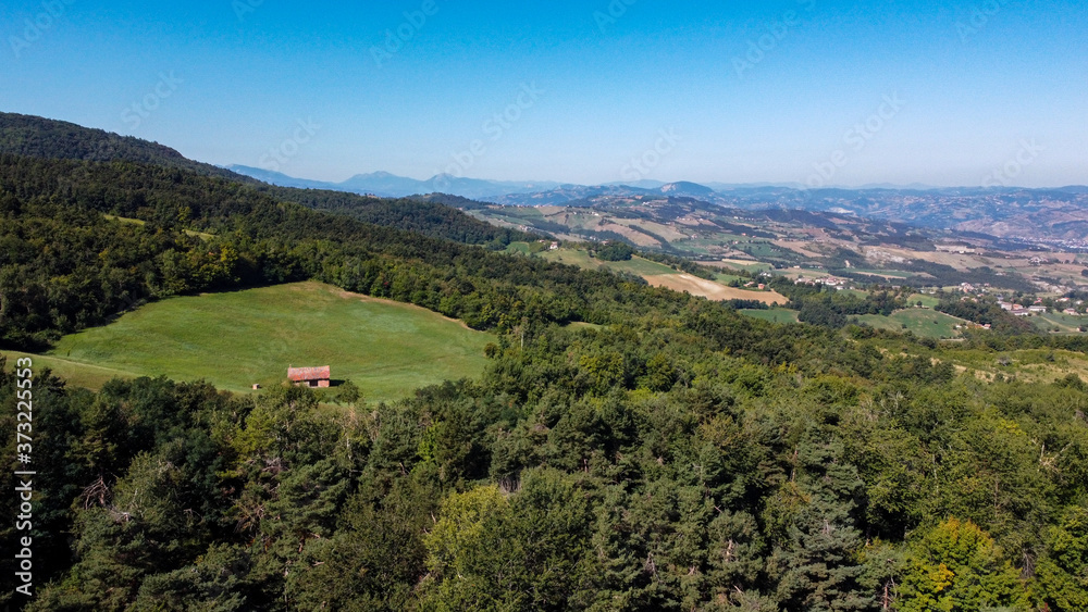 Fototapeta premium Vista aerea delle colline sugli Appennini modenesi, Italia, con campi, prati e boschi