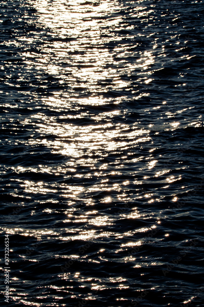 Tranquil and shiny water texture in a summer river, sea, ocean or swimming pool.