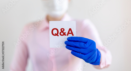 Q and A text word inscription acronym on paperin hands of doctor. medical questions and answers concept photo