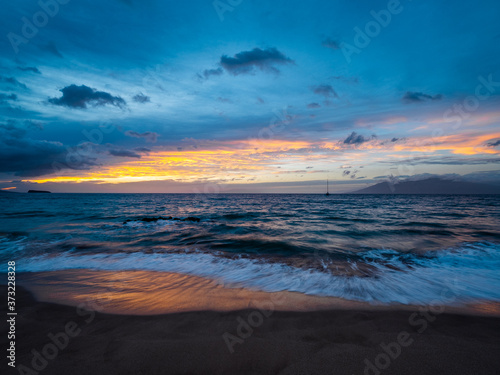Amazing sunset and boat on the horizon. Beautiful nature of Hawaii