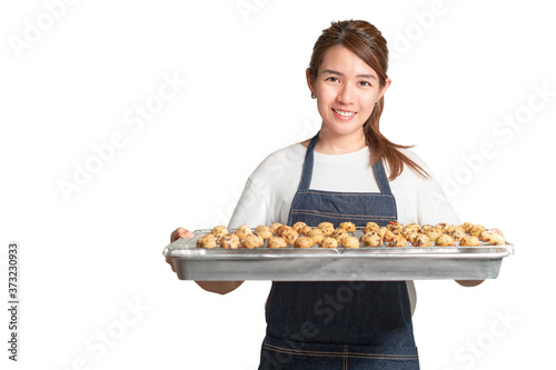 Asian woman smiling wear white t-shirt with apron holding tray with cookies isolate on white background  With clipping path.