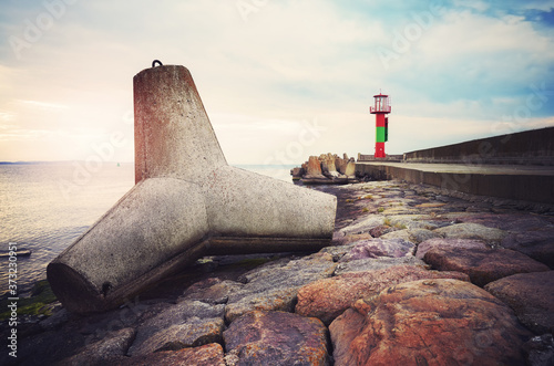 Concrete tetrapod breakwater on a pier in Swinoujscie at sunset, color toned picture, Poland. photo